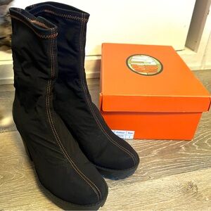 Hot Lava Runner Boots in Black. Stretchy sock boot with orange contrast stitch